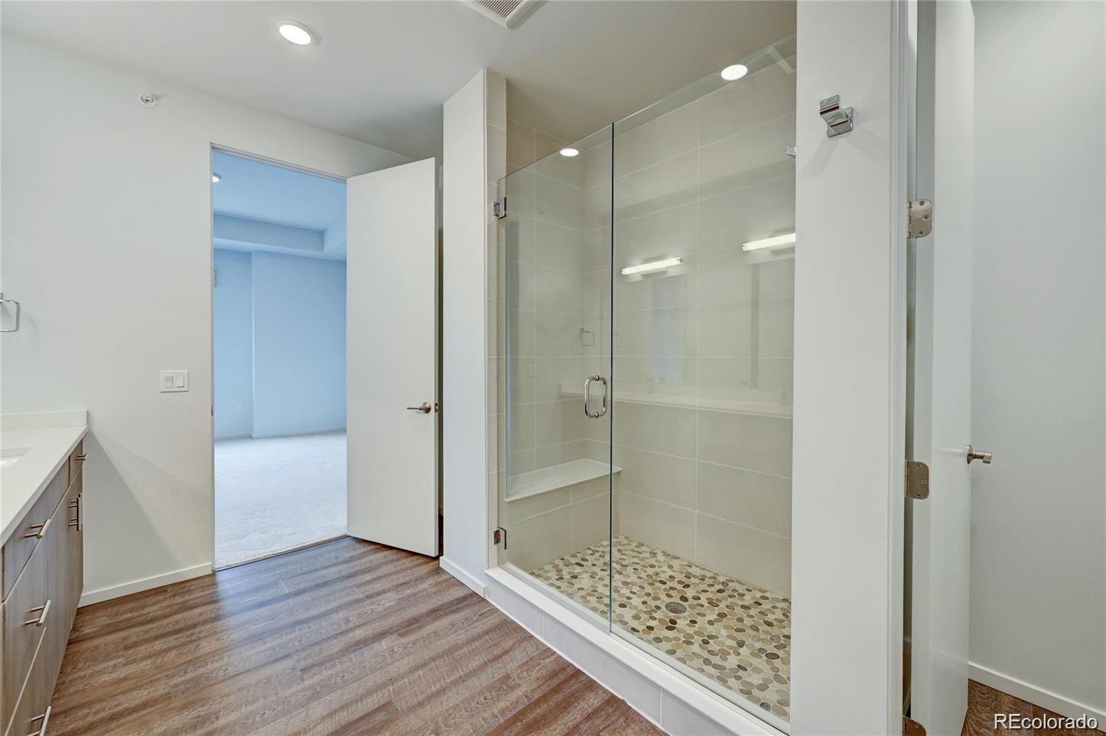 31191 Black Eagle Drive, Unit 301 Evergreen, CO 80439 - Photo 18 of 35 a bathroom with a glass shower door and a bathtub