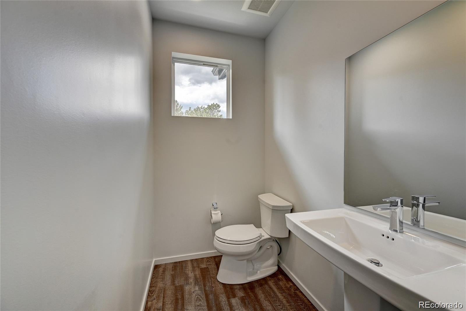 31191 Black Eagle Drive, Unit 301 Evergreen, CO 80439 - Photo 25 of 35 a bathroom with a toilet a sink and mirror