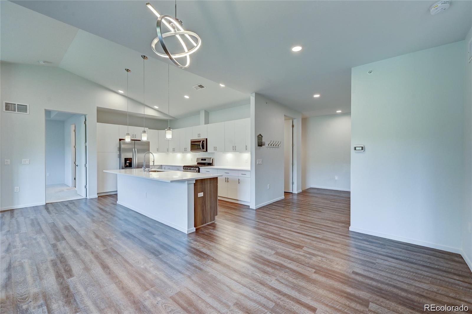 31191 Black Eagle Drive, Unit 301 Evergreen, CO 80439 - Photo 5 of 35 a large kitchen with kitchen island a sink stainless steel appliances and cabinets