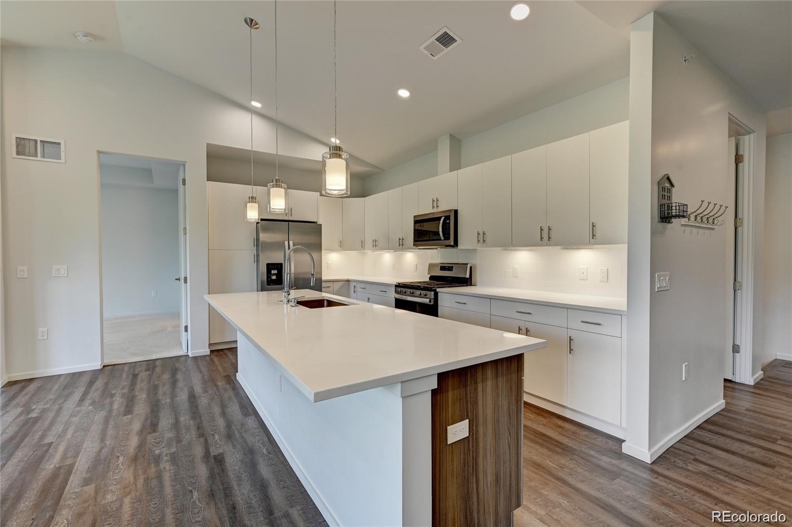 31191 Black Eagle Drive, Unit 301 Evergreen, CO 80439 - Photo 6 of 35 a large kitchen with a center island and stainless steel appliances