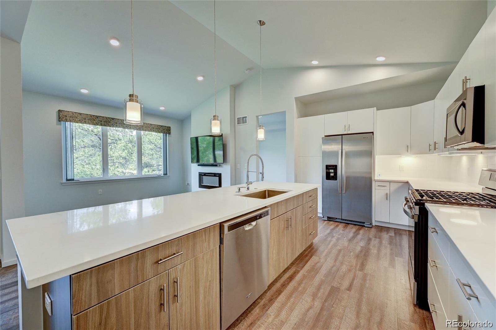 31191 Black Eagle Drive, Unit 301 Evergreen, CO 80439 - Photo 8 of 35 a large kitchen with stainless steel appliances a large window a sink and a refrigerator