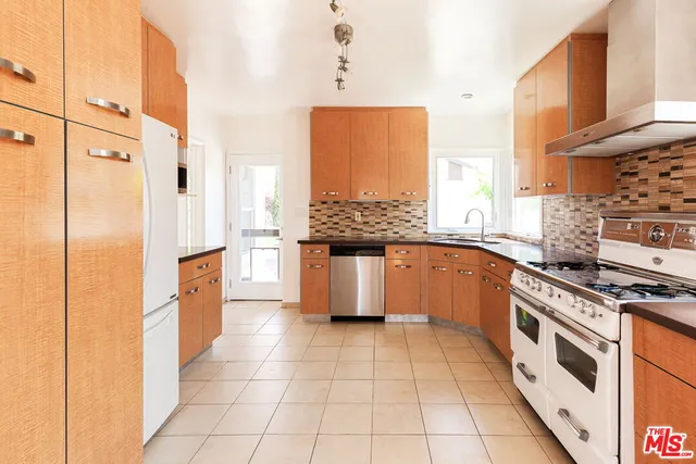 a kitchen with stainless steel appliances granite countertop a stove a sink and a refrigerator