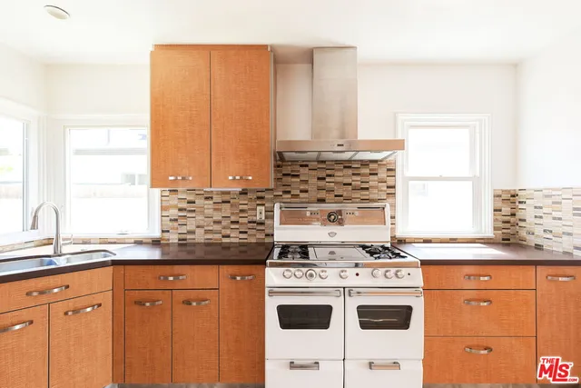 a kitchen with granite countertop a sink a stove and a refrigerator