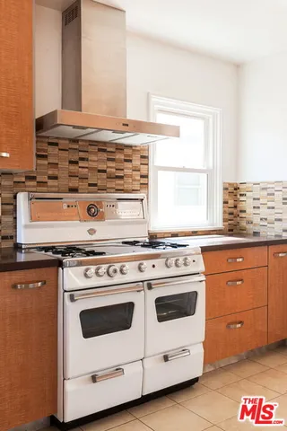 a white stove top oven sitting inside of a kitchen