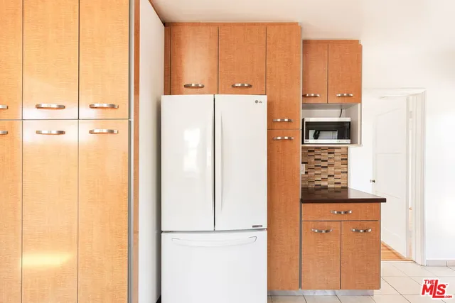 a view of a kitchen with refrigerator and wooden floor