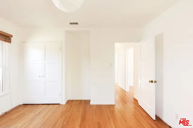 a view of a room with wooden floor and white walls