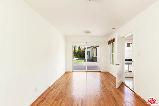 a view of a big room with wooden floor and windows