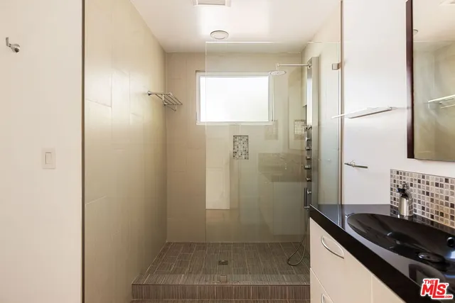a bathroom with a granite countertop sink a shower and a mirror