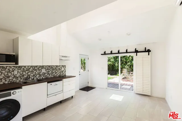 a view of a kitchen with furniture and white cabinets
