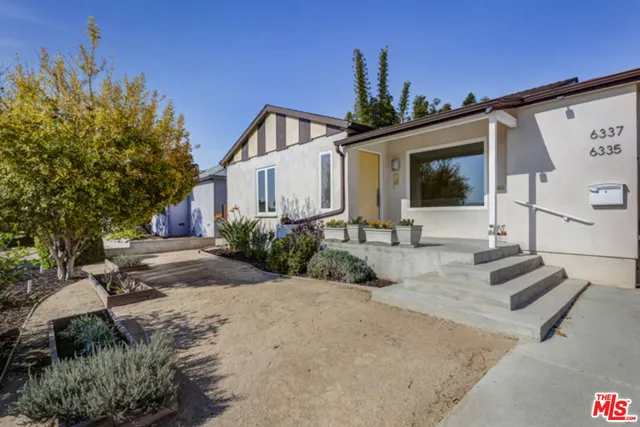 a front view of house with yard outdoor seating and plants