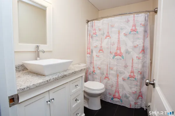 a bathroom with a granite countertop sink and a mirror