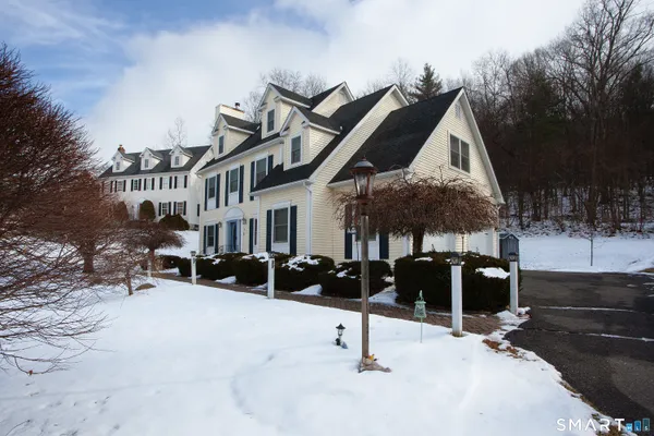 a front view of a house with a yard covered in snow