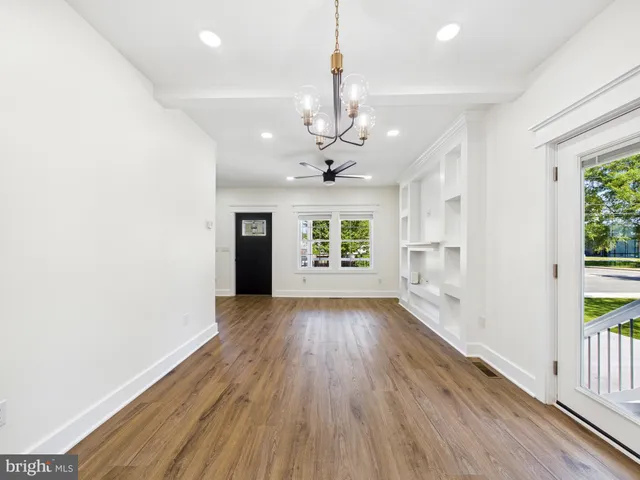 a view of a room with wooden floor and a ceiling fan