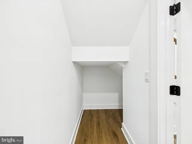 an empty room with wooden floor ceiling fan and windows