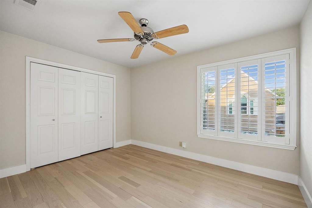 4115 Rive Lane Addison, TX 75001 - Photo 16 of 25 Bright room featuring light wood-finish flooring, white plantation shutters, a ceiling fan with wood-finish blades, and bi-fold closet doors