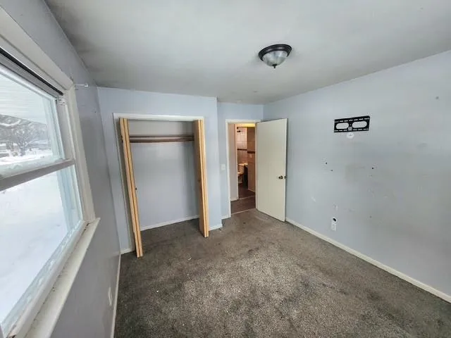 a view of empty room with wooden floor and window