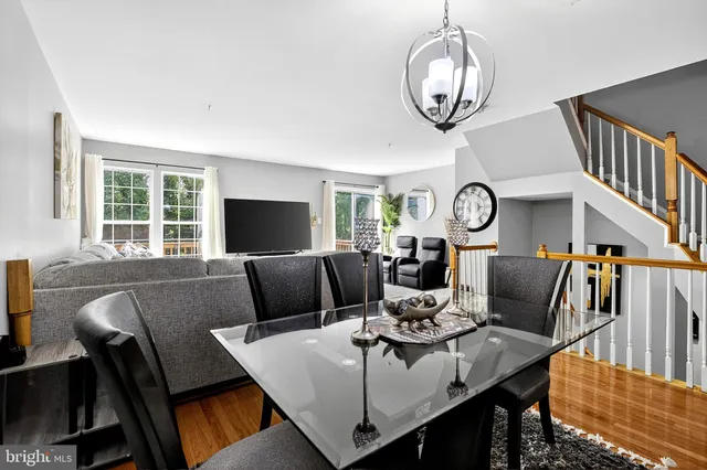 a view of a dining room with furniture a chandelier and wooden floor