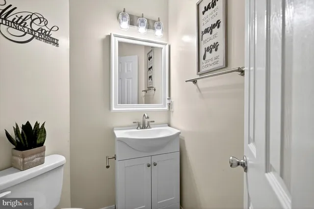 a bathroom with a sink a mirror and a potted plant