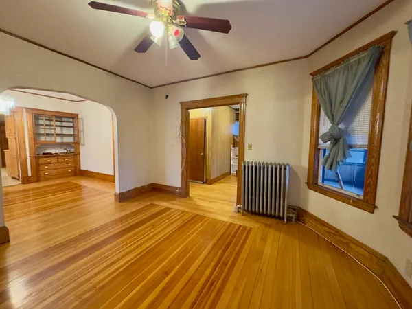 a view of an empty room with wooden floor