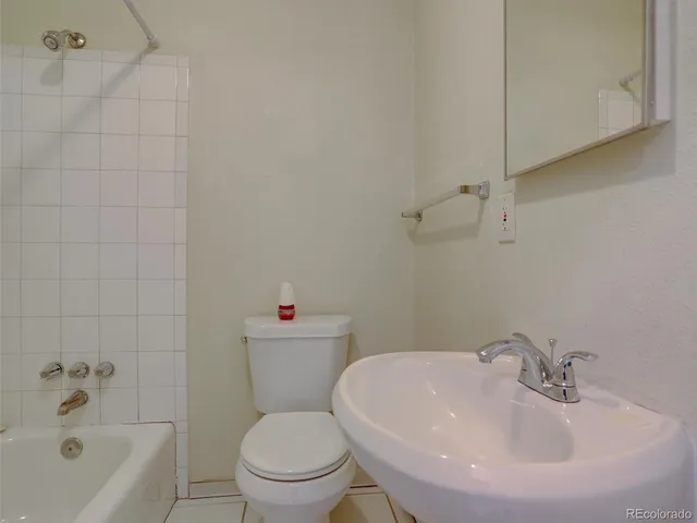 a view of an empty room with wooden floor and closet