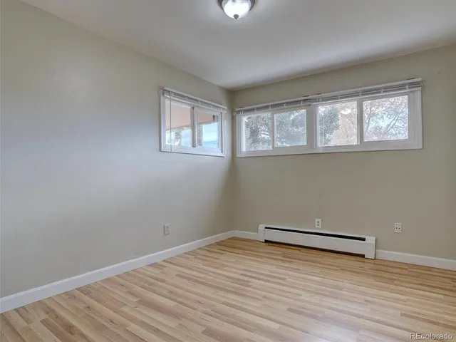 an empty room with a fireplace and natural light