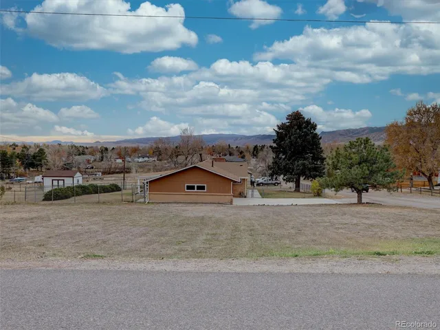 a view of a dry yard with wooden fence