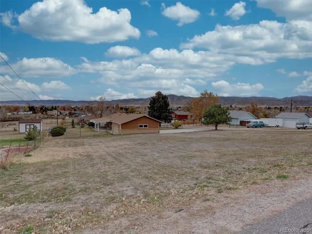 an empty room with wooden floor fireplace and windows