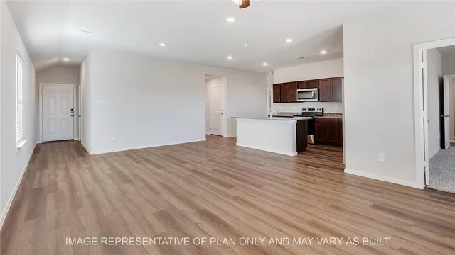 a view of living room with kitchen island stainless steel appliances wooden floor and living room view