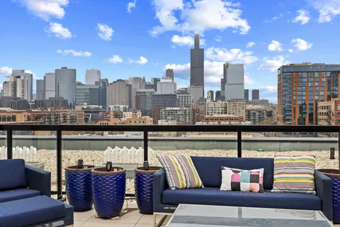 a view of city from a balcony with seating space