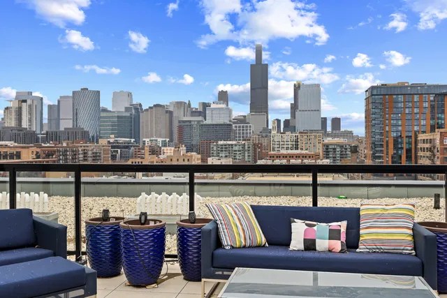 a view of city from a balcony with seating space