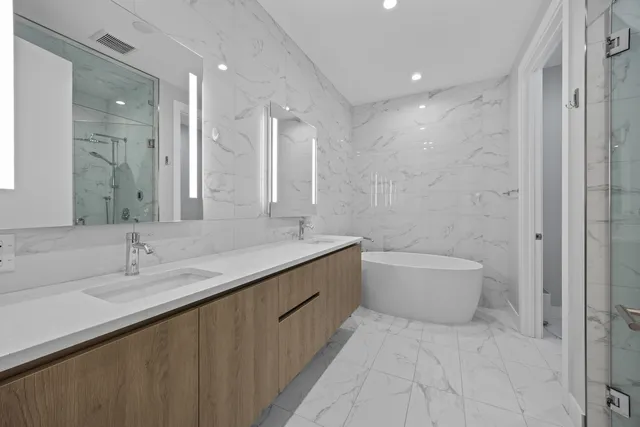 a bathroom with a double vanity sink toilet and shower