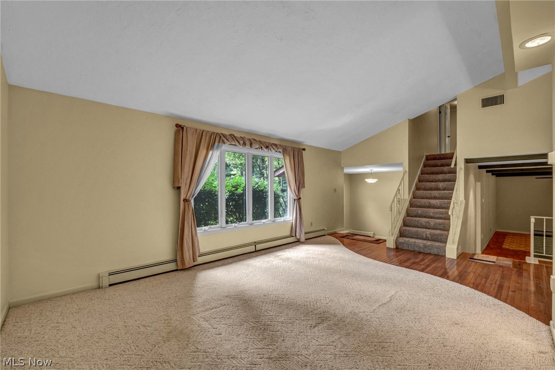 6845 Liberty Road Solon, OH 44139 - Photo 7 of 47 Inviting living area featuring a large picture window, vaulted ceiling, and baseboard heating