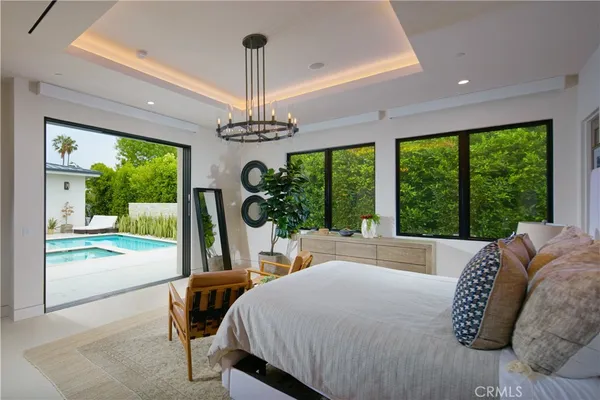 a bed sitting in a bedroom next to a large window with a garden view