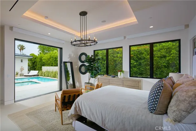 a bed sitting in a bedroom next to a large window with a garden view