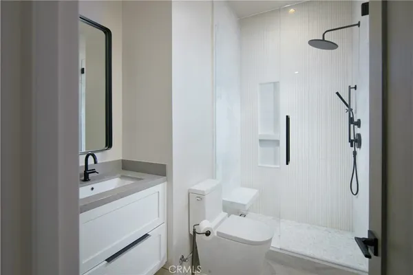 a bathroom with a granite countertop sink toilet and shower