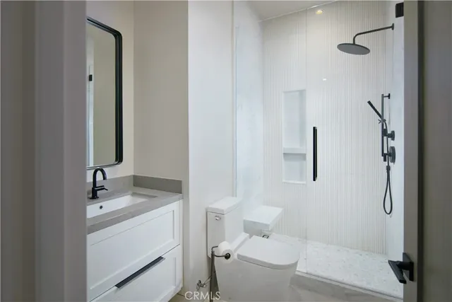 a bathroom with a granite countertop sink toilet and shower