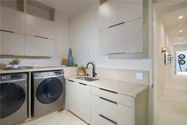 a utility room with sink dryer and washer
