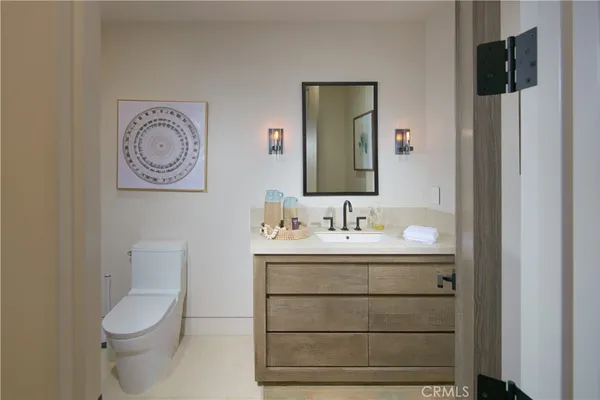 a bathroom with a toilet sink vanity and mirror
