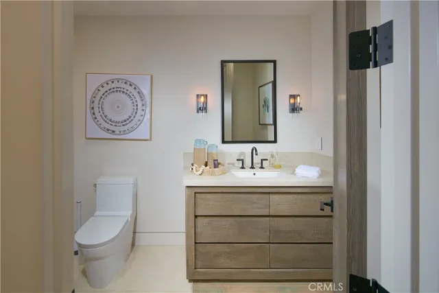 a bathroom with a toilet sink vanity and mirror