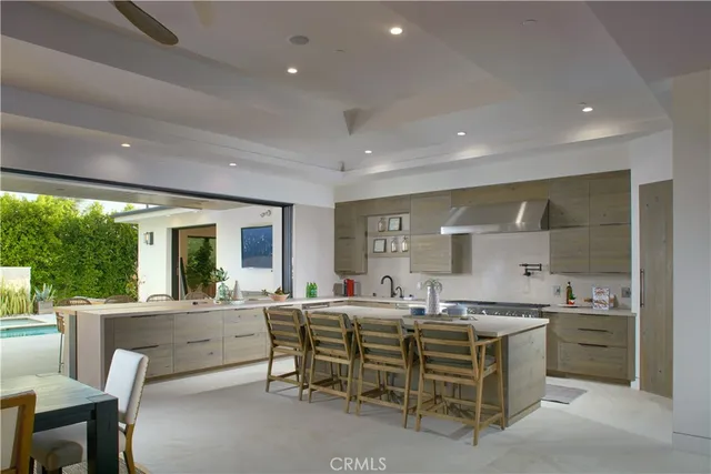 a living room with stainless steel appliances kitchen island furniture and a large window
