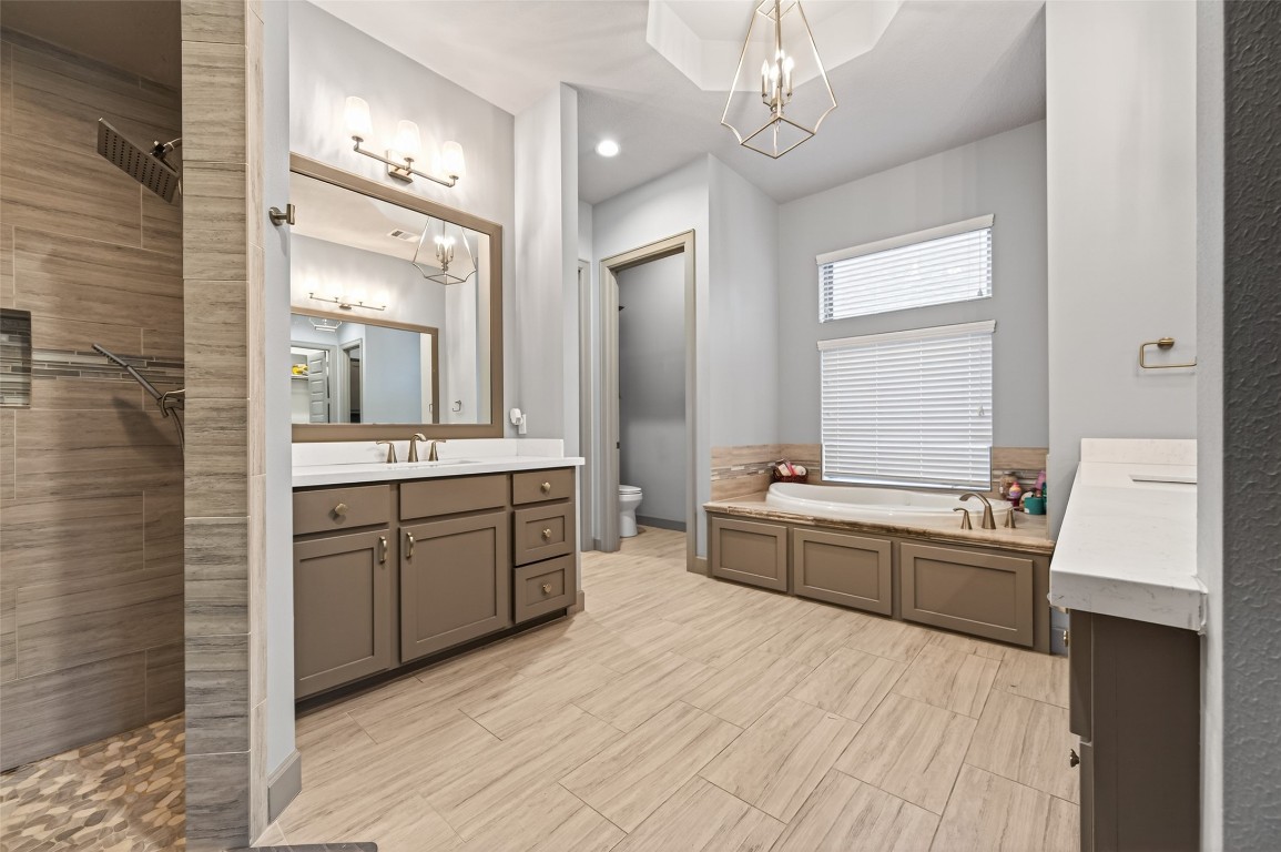 12379 Pebble View Drive Conroe, TX 77304 - Photo 26 of 49 a large bathroom with a sink a large mirror and a bathtub