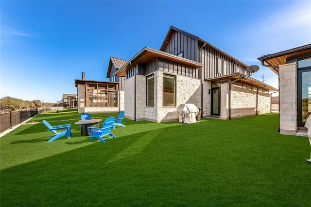 a view of swimming pool that has lawn chairs and a dining table under an umbrella