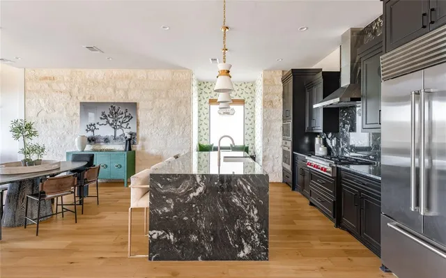 a kitchen with stainless steel appliances granite countertop a sink a stove and a refrigerator