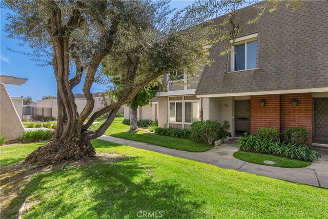a view of a house with garden and a tree