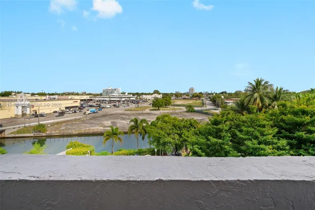 an aerial view of a houses with a yard and ocean view