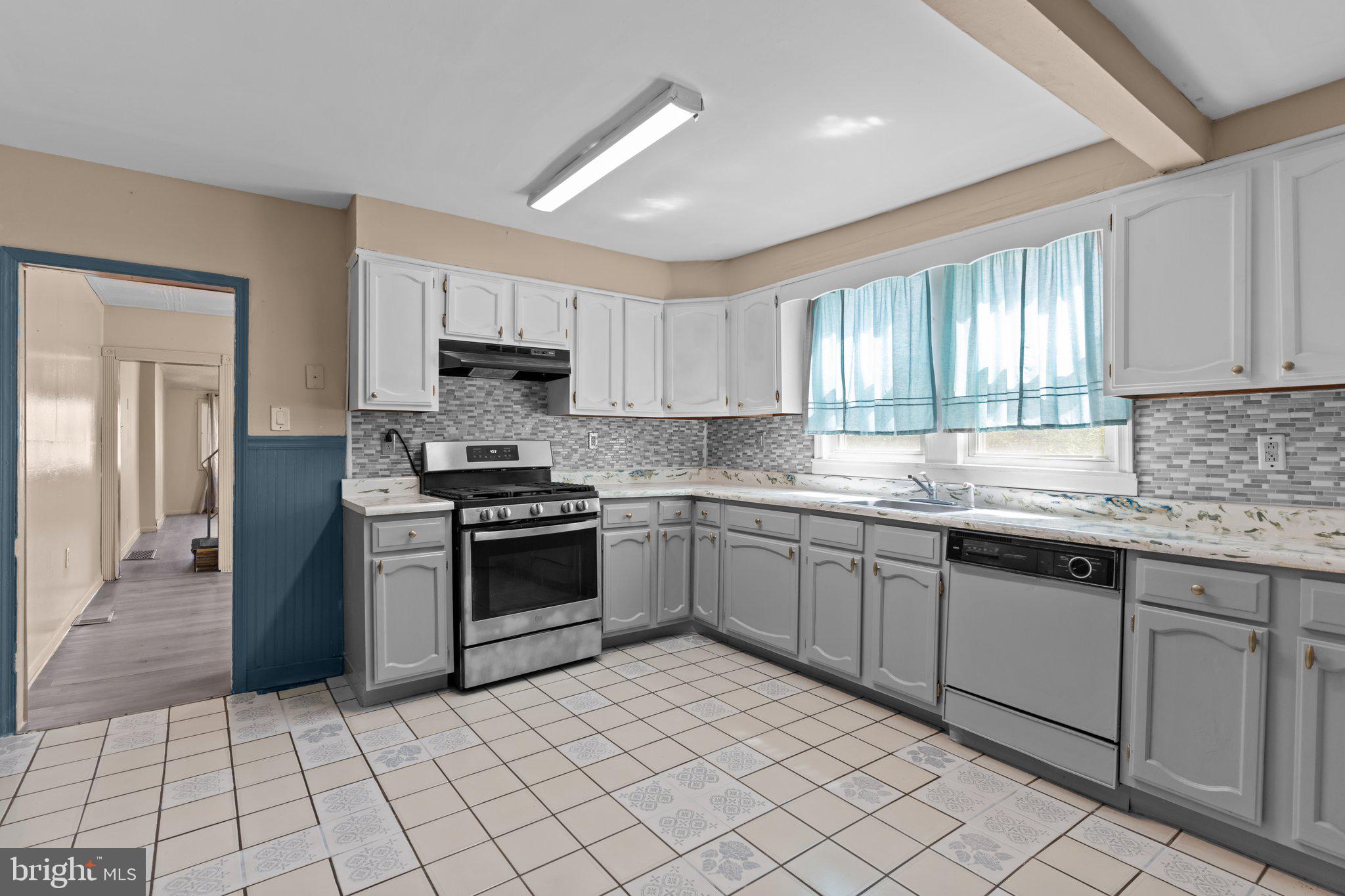 129 Blake Avenue Rockledge, PA 19046 - Photo 11 of 19 a kitchen with granite countertop a stove sink and cabinets
