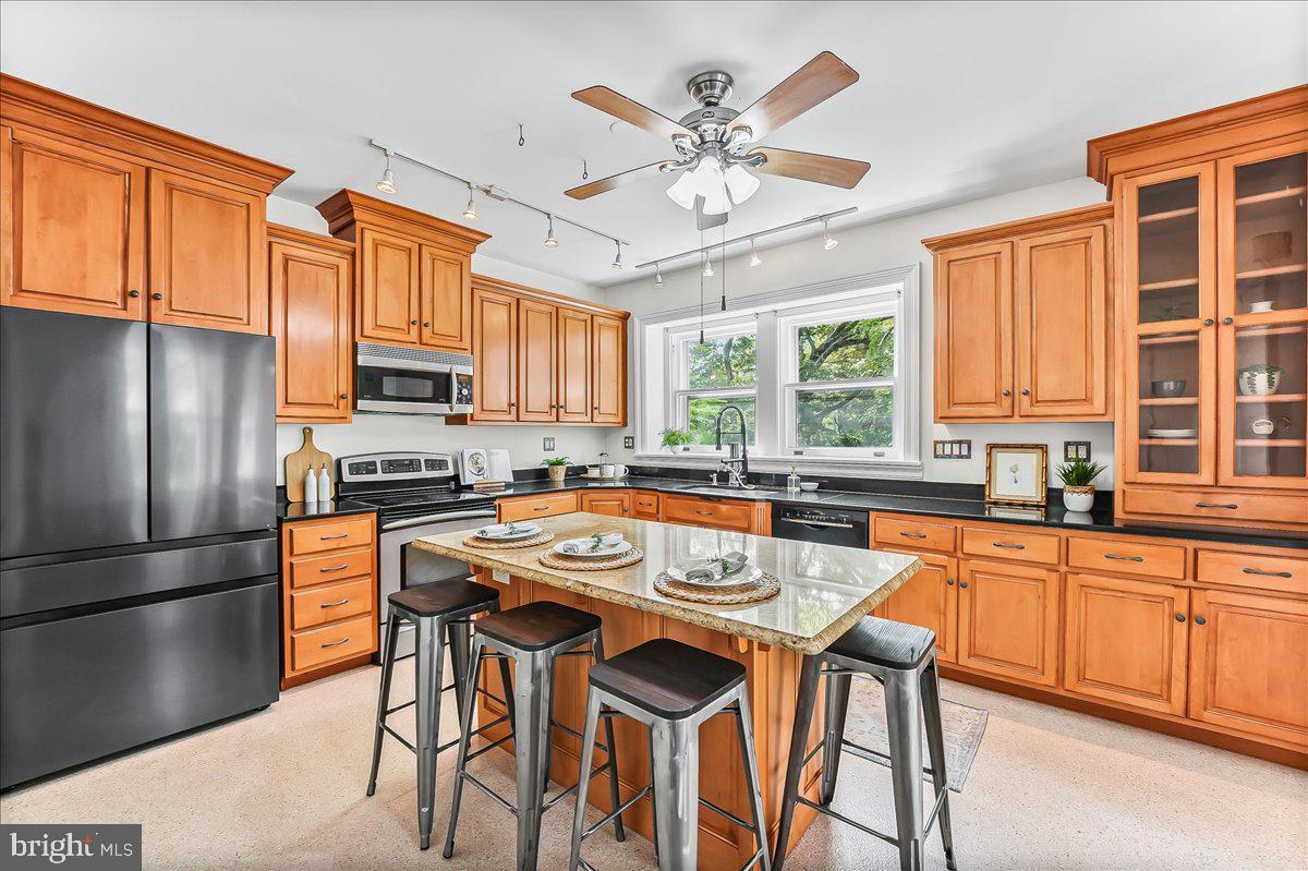 503 West State Street Kennett Square, PA 19348 - Photo 20 of 76 a kitchen with stainless steel appliances granite countertop a stove a sink dishwasher a refrigerator with a dining table and chairs