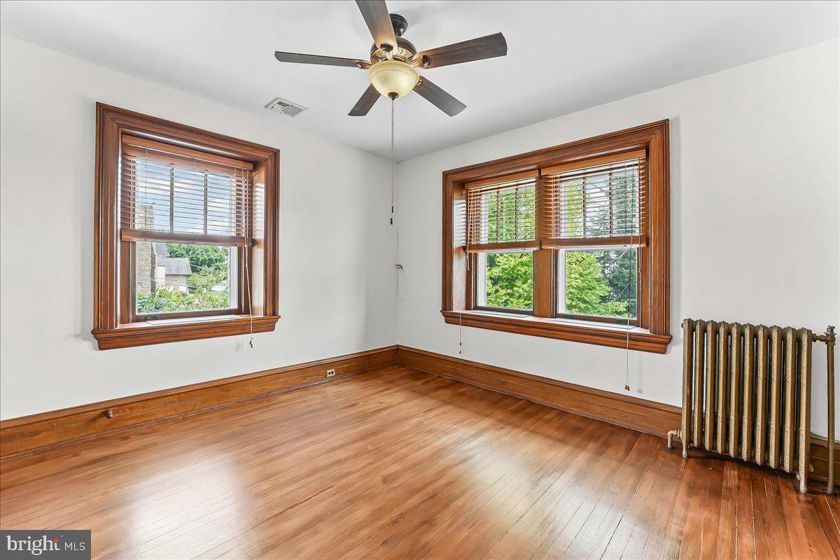 503 West State Street Kennett Square, PA 19348 - Photo 31 of 76 an empty room with wooden floor chandelier fan and windows