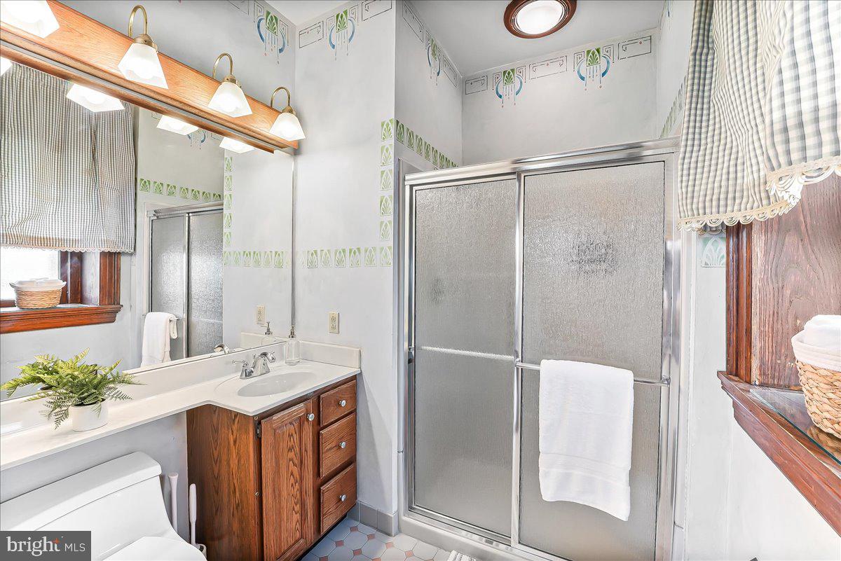 503 West State Street Kennett Square, PA 19348 - Photo 33 of 76 a bathroom with a double vanity sink a large mirror and shower
