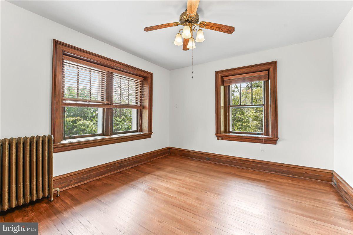 503 West State Street Kennett Square, PA 19348 - Photo 34 of 76 an empty room with wooden floor chandelier and windows